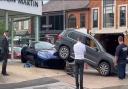 A Volkswagen Tiguan mounted the bonnet of an Aston Martin parked on a dealership forecourt in Wilmslow