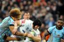 Fiji getting to grips with England's Chris Hill last Saturday