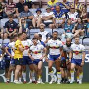 A dejected-looking Wire side during their Challenge Cup loss at Wigan Warriors