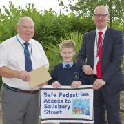 Tyler with Clr Peter Carey and Clr Tony Higgins and his winning artwork which has now become a road sign