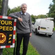 Cllr Brian Axcell next to the speed meter in Appleton