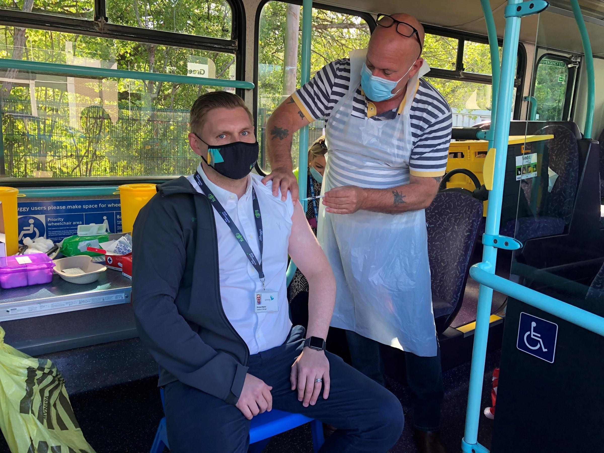 Operations manager Richard Martin receives his coronavirus vaccine aboard the bus