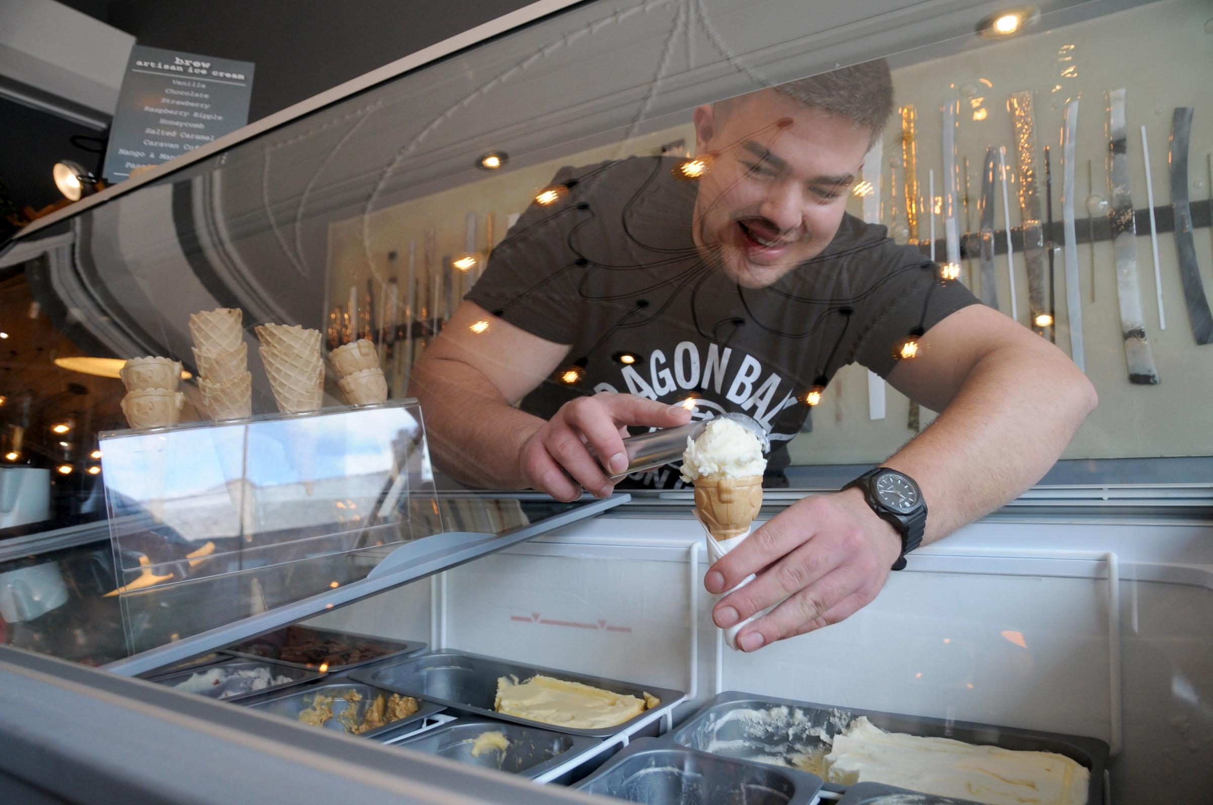 Matteo Johnson serves an ice cream from Brews new ice cream bar