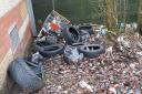 Old tyres and a trolley dumped on land near B&Q in Winwick