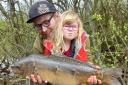 Warrington Anglers' Association members Sophia Manley and her dad John with the mirror carp she caught at The Mount