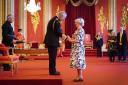 Marie McCourt being given her MBE by King Charles III