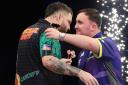 Luke Littler and Michael Smith embrace after their Premier League semi-final in Cardiff