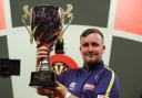 Warrington's Luke Littler lifting the JDC World Championship trophy in 2022
