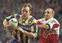Greg Mackey looks to escape the clutches of Wigan's Shaun Edwards