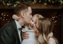 Newlyweds Rachel and Matthew share a kiss on their wedding day with daughter Willow
