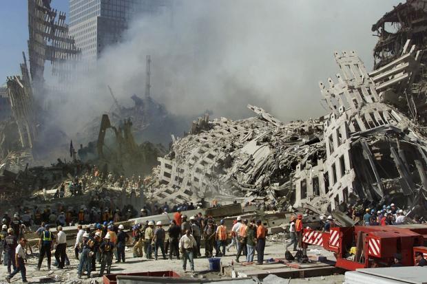 FILE - In this Thursday, Sept. 13, 2001 file photo, rescue workers continue their search as smoke rises from the rubble of the World Trade Center in New York. Twenty years on, the skepticism and suspicion first revealed by 9/11 conspiracy theories has