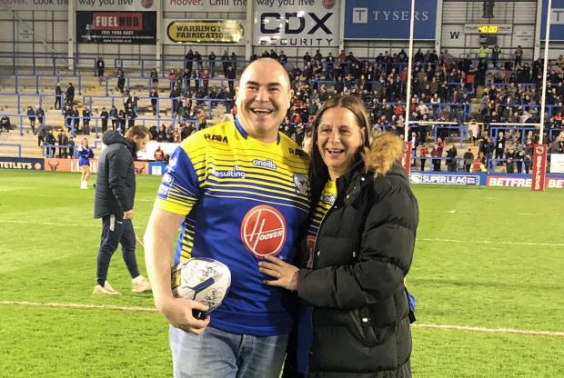 Warrington Guardian: A tender moment for Kevin Hatton and Sarah Salisbury after she said 'yes' to his marriage proposal on the Halliwell Jones Stadium pitch during the interval of the Warrington Wolves versus Salford Red Devils game on Thursday, April 14, 2022. Picture: Warrington Wolves