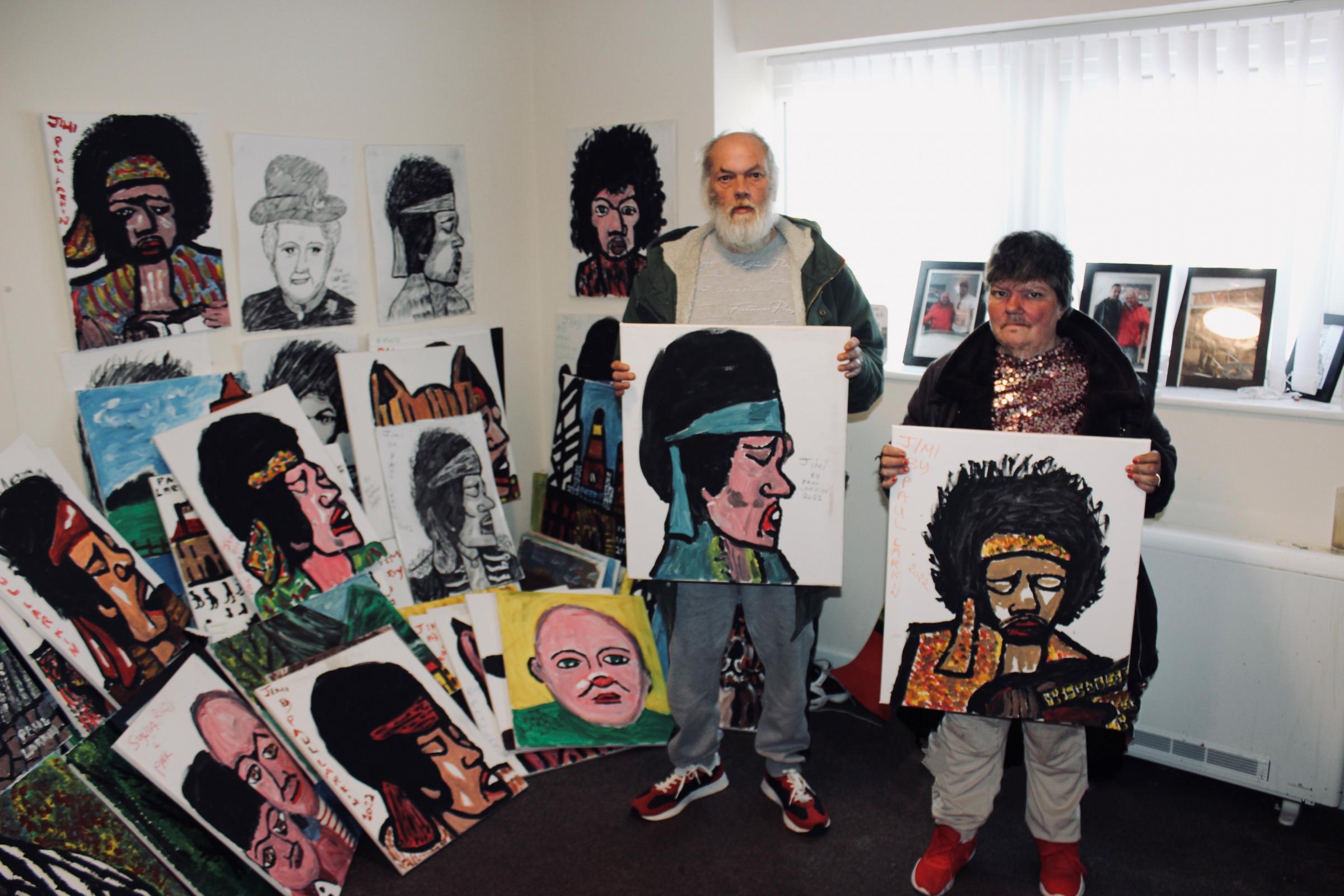 Paul with his wife Sylvia alongside some of his paintings