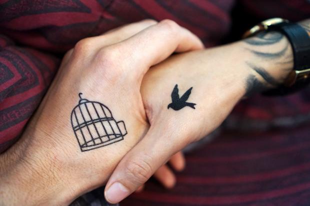 Warrington Guardian: Two people with tattoos holding hands (Canva)