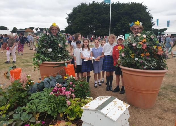 Warrington Guardian: Croft Primary School pupils having fun with the Tatton walking flower pots Picture: Michelle Culliford