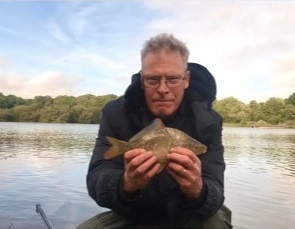 Phil Brown with the baby mirror carp he caught in the same session at Appleton Reservoir