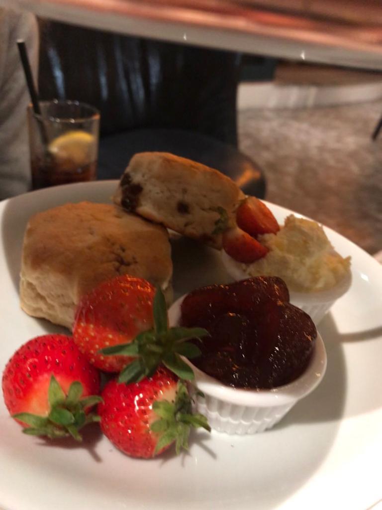 Scones served with jam and clotted cream with fresh strawberries