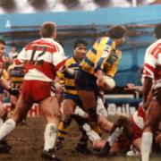 1. Who is the Warrington Wolves player with the ball in his hand? Answer: Neil Harmon