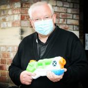 Father Dave Heywood with the water gun