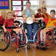 Liverpool Lions Wheelchair Rugby Club player-manager Martin Beddis with Stockton Heath Primary School pupils