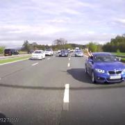 The driver was caught in a rear camera waving his arms out of the window