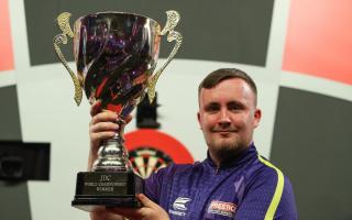 Warrington's Luke Littler lifting the JDC World Championship trophy in 2022